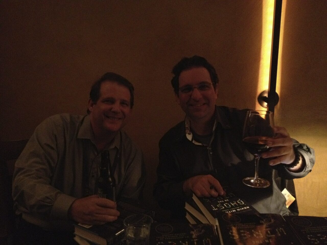 Kevin Mitnick and Shawn Nunley at a restaurant with Kevin's book Ghost in the Wires on the table