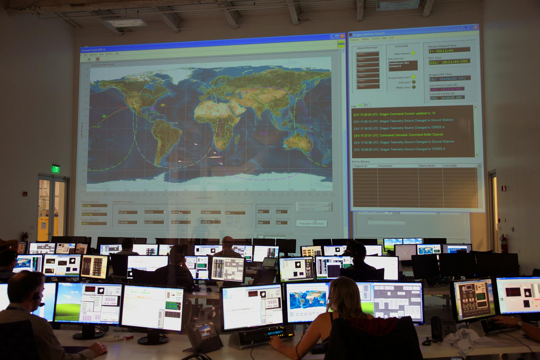 Wide shot of a control room with operators working in front of large display screens