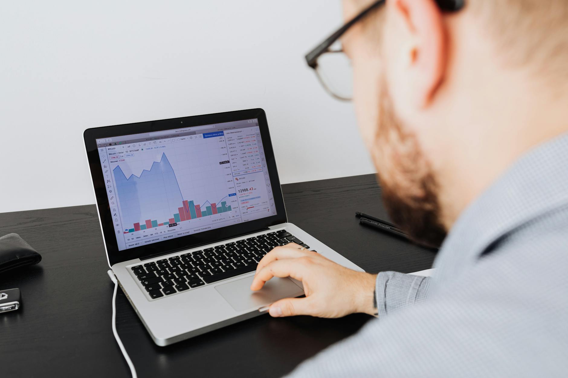 Man analyzing business data and financial graphs on a laptop