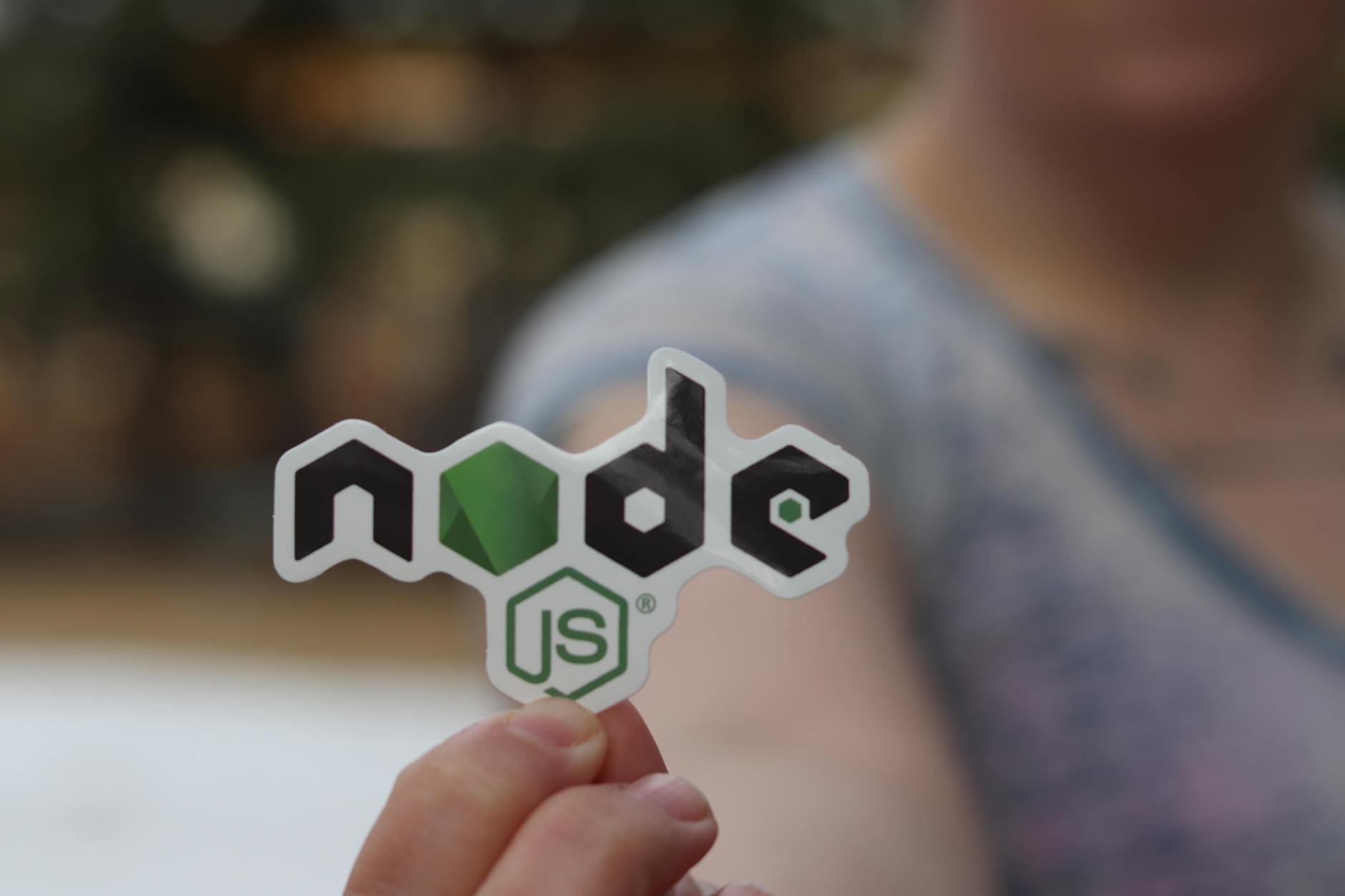 A person holding an open-source project sticker, close-up shot