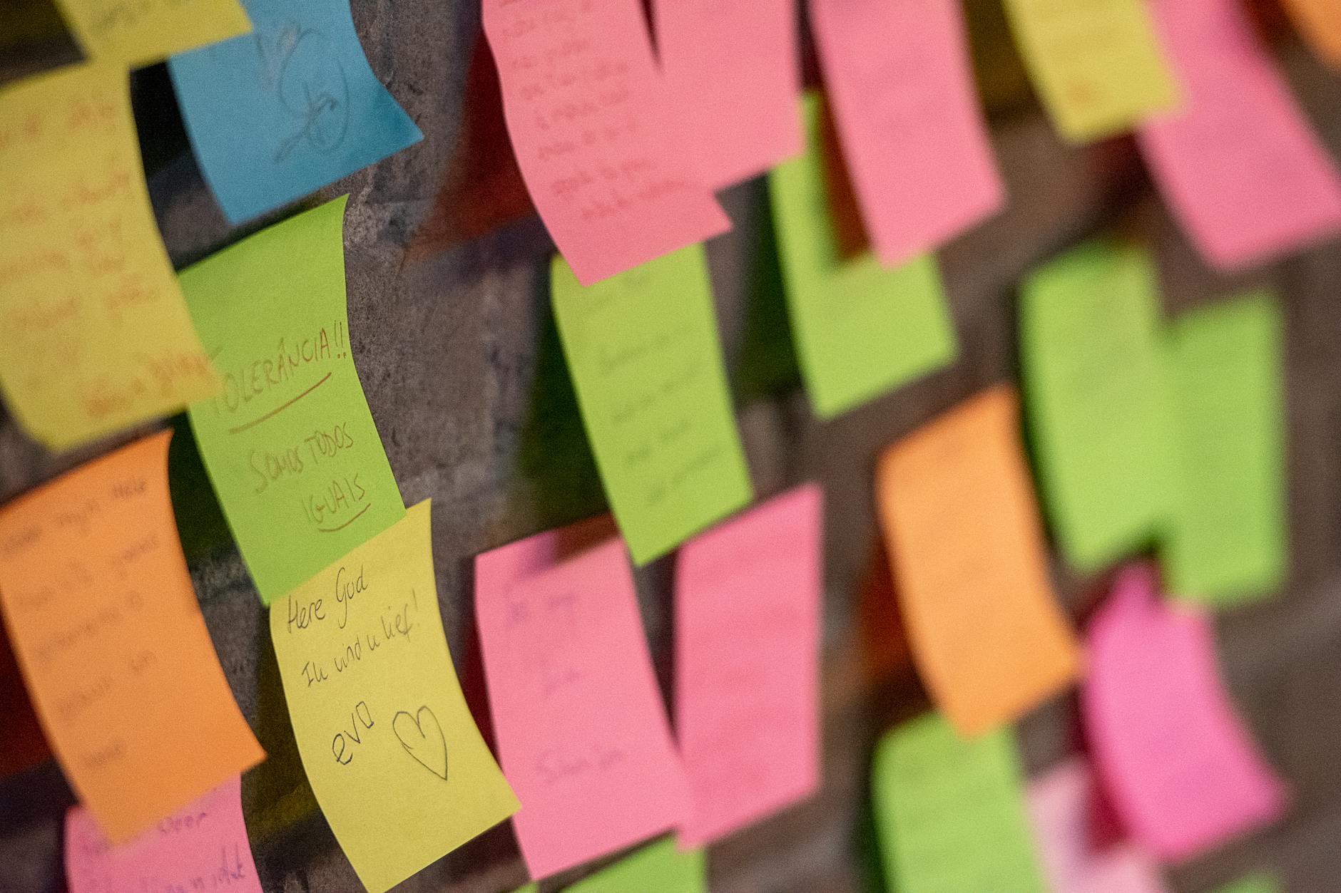 Close-up of colorful sticky notes on a wall, conveying messages and reminders